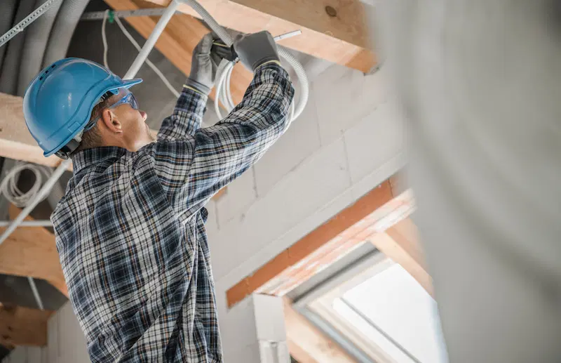 An electrical contractor working on ceiling light installation